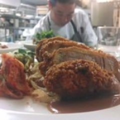a person sitting at a table with a plate of food