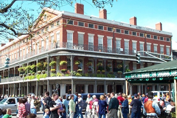 a group of people walking in front of Pontalba Buildings