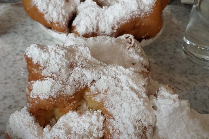 a hand holding a piece of cake covered in snow