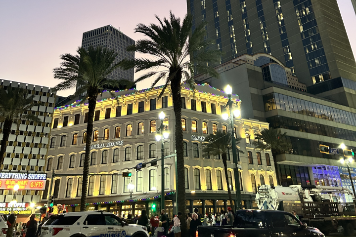 Cityscape with tall buildings and palm trees at dusk.