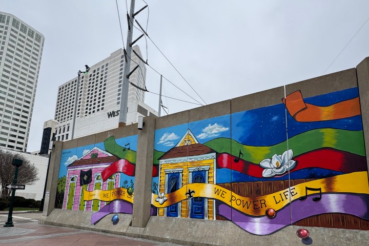 Colorful mural on a city wall with buildings and musical notes.