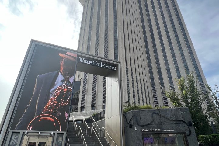 Tall building with Vue Orleans sign and large saxophone player image on entrance