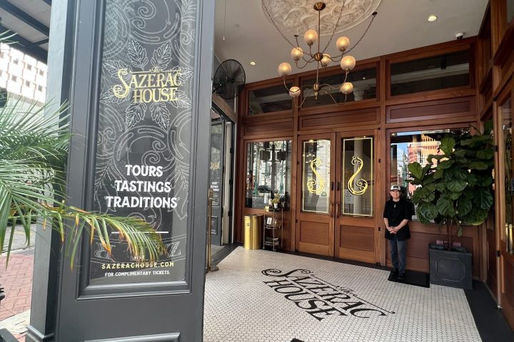 Entrance of Sazerac House with tiles and chandelier, and a sign for tours and tastings.